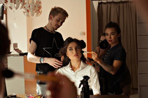beauty school students styling the hair of a client