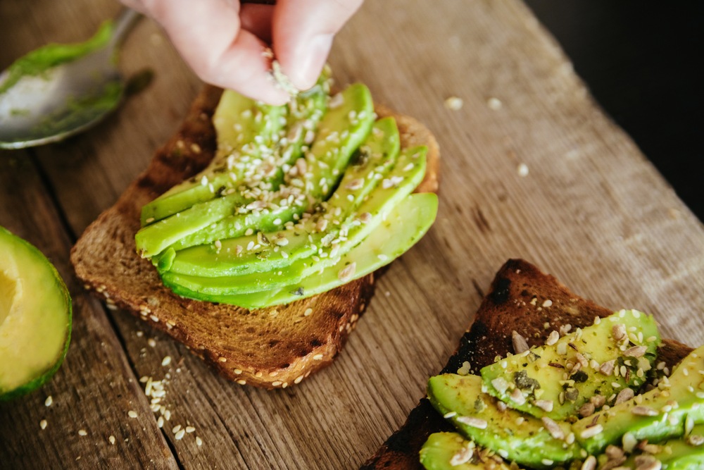 Avocado toast on dark bread sprinkled with seasonings.