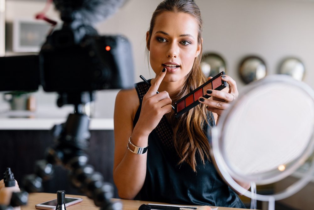 beauty blogger showing eyeshadow palette to camera