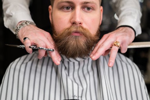 barber checking the length of a client's beard for balance