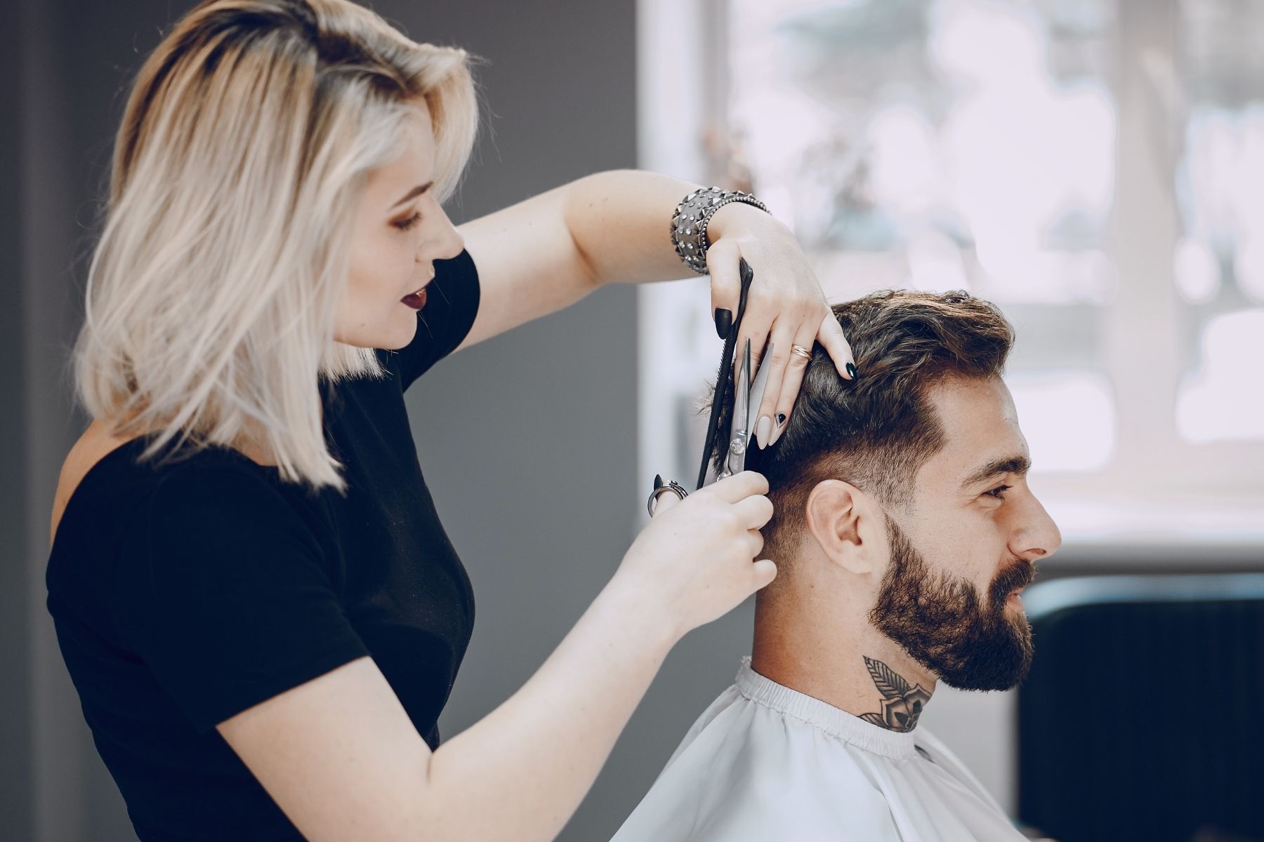 Hairstylist cutting man's hair