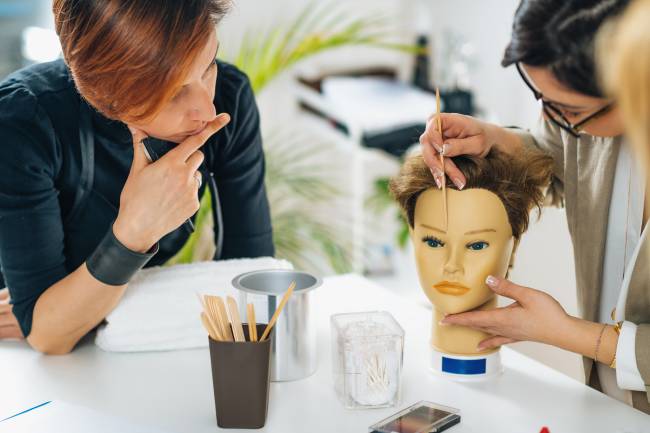 two women studying a mannequin