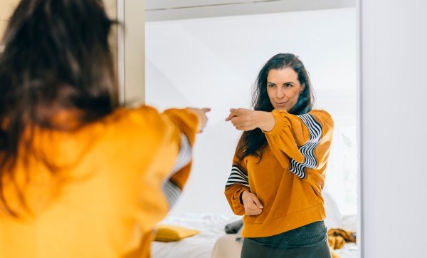 woman pointing to herself in the mirror